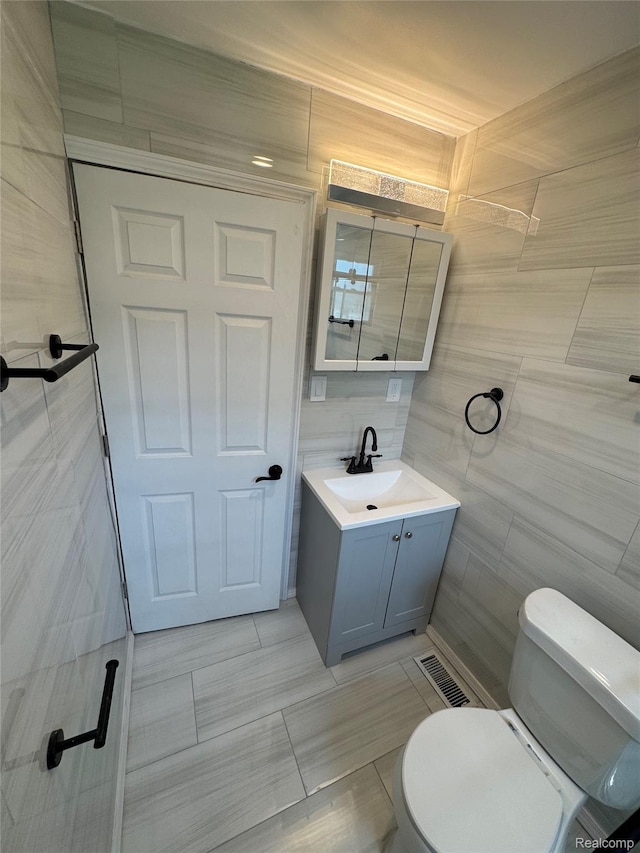 1112 Brockway Rd, Saginaw, MI 48602 - bathroom featuring tile walls, vanity, and tile patterned floors