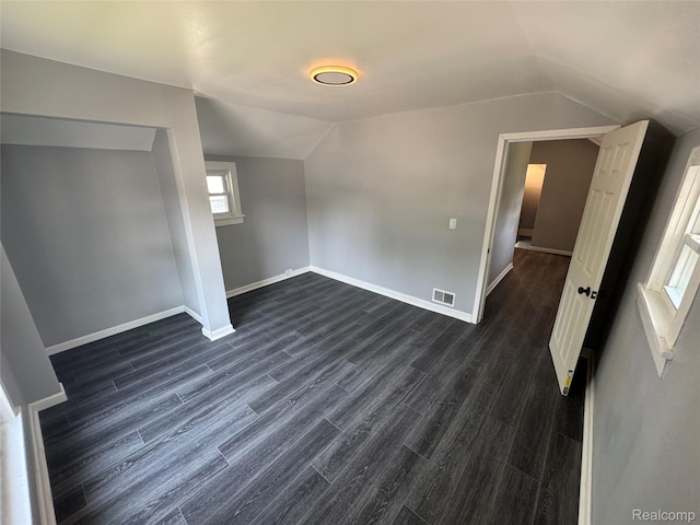1112 Brockway Rd, Saginaw, MI 48602 - unfurnished bedroom featuring vaulted ceiling and dark wood-style floors