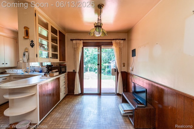 526 W Webster Rd, Royal Oak, MI 48073 - kitchen with open shelves, a wainscoted wall, light countertops, brick patterned floors, and a peninsula