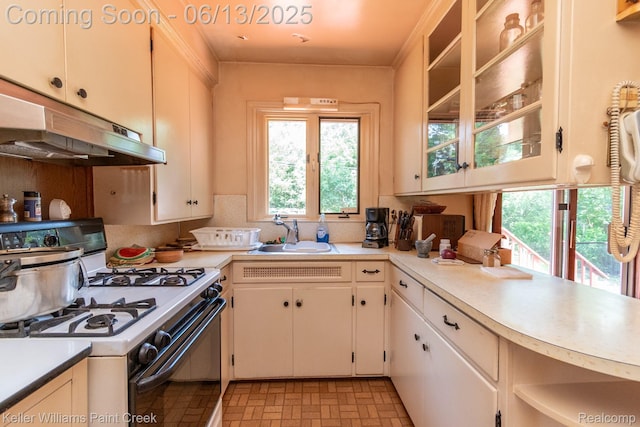 526 W Webster Rd, Royal Oak, MI 48073 - kitchen with white range with gas cooktop, under cabinet range hood, light countertops, brick patterned floors, and backsplash
