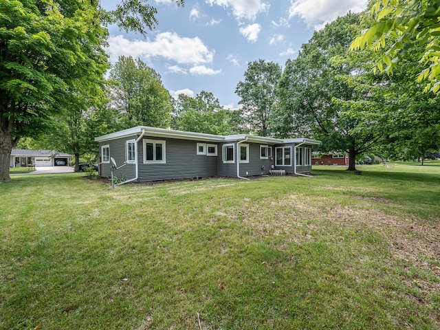 219 Park St, Tecumseh, MI 49286 - rear view of house featuring a yard, view of scattered trees, and a sunroom