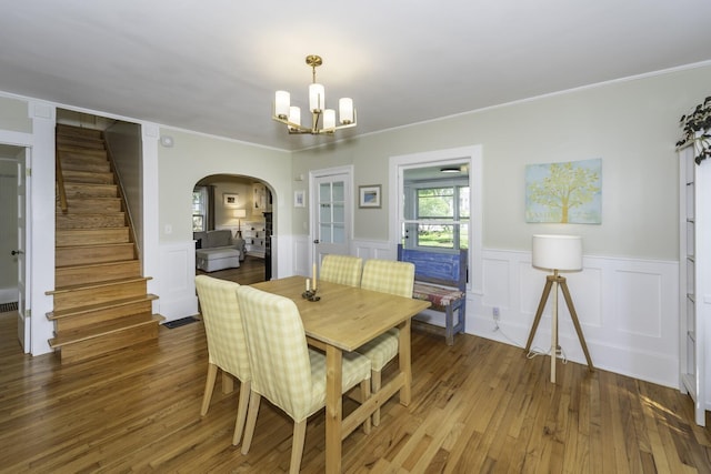 3444 Broad St, Dexter, MI 48130 - dining area featuring arched walkways, a chandelier, stairs, crown molding, and wainscoting