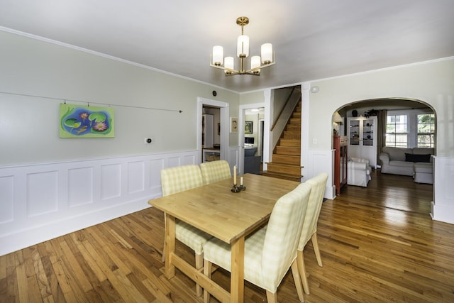 3444 Broad St, Dexter, MI 48130 - dining area with arched walkways, wood finished floors, a chandelier, crown molding, and a wainscoted wall