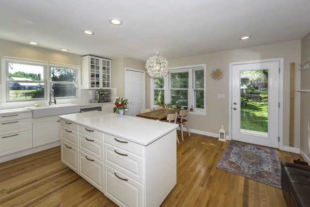 3444 Broad St, Dexter, MI 48130 - kitchen featuring light wood-style floors, light countertops, white cabinets, a center island, and glass insert cabinets