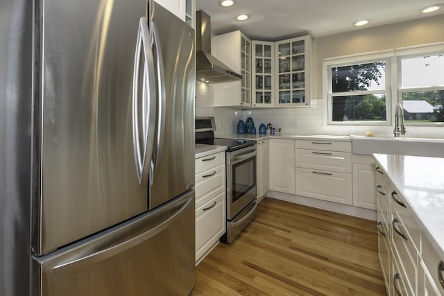 3444 Broad St, Dexter, MI 48130 - kitchen featuring appliances with stainless steel finishes, wall chimney range hood, white cabinetry, glass insert cabinets, and recessed lighting