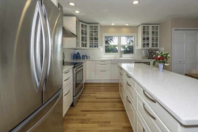 3444 Broad St, Dexter, MI 48130 - kitchen with stainless steel appliances, light wood-type flooring, recessed lighting, backsplash, and white cabinetry