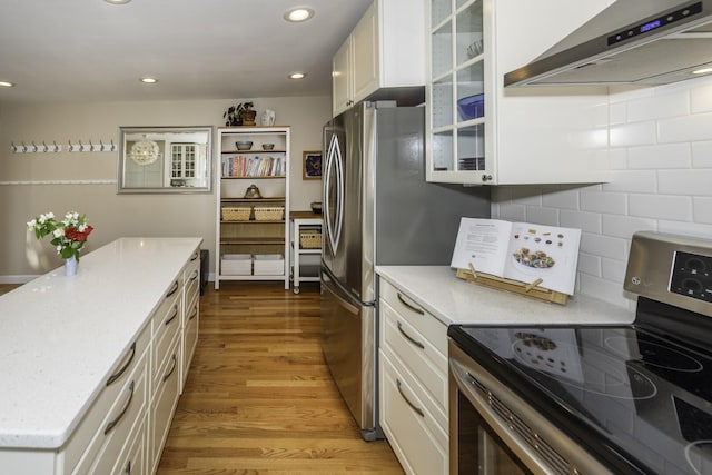 3444 Broad St, Dexter, MI 48130 - kitchen with stainless steel range with electric cooktop, wall chimney exhaust hood, light wood-style flooring, white cabinets, and glass insert cabinets