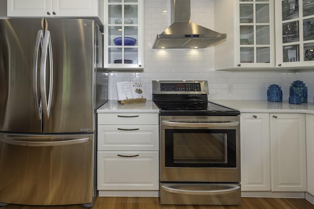 3444 Broad St, Dexter, MI 48130 - kitchen featuring appliances with stainless steel finishes, wall chimney exhaust hood, light countertops, white cabinetry, and glass insert cabinets