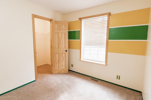 4100 Maloney Rd, Pinconning, MI 48650 - unfurnished bedroom featuring carpet, a spacious closet, and a closet