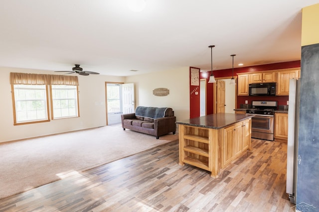 4100 Maloney Rd, Pinconning, MI 48650 - kitchen featuring gas stove, black microwave, open floor plan, dark countertops, and light wood finished floors