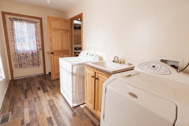 4100 Maloney Rd, Pinconning, MI 48650 - washroom featuring cabinet space, separate washer and dryer, and wood finished floors