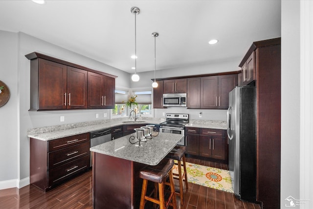 696 Webber Dr, Temperance, MI 48182 - kitchen with appliances with stainless steel finishes, a center island, dark wood-style floors, light stone countertops, and dark brown cabinetry