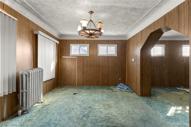 3966 12th St, Ecorse, MI 48229 - unfurnished dining area with radiator, a chandelier, plenty of natural light, carpet, and wood walls