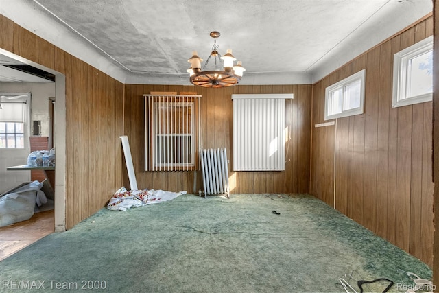 3966 12th St, Ecorse, MI 48229 - unfurnished dining area featuring plenty of natural light, a chandelier, carpet, and wooden walls