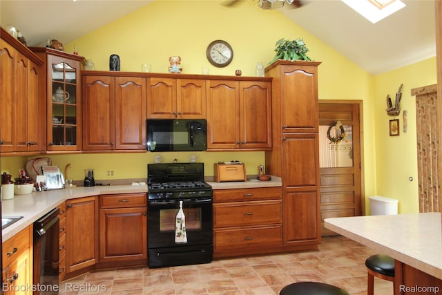 32599 Armada Ridge Rd, Richmond, MI 48062 - kitchen featuring black appliances, vaulted ceiling, light countertops, glass insert cabinets, and a skylight