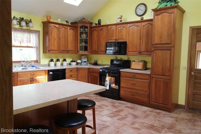 32599 Armada Ridge Rd, Richmond, MI 48062 - kitchen featuring black appliances, vaulted ceiling, a kitchen breakfast bar, light countertops, and brown cabinetry
