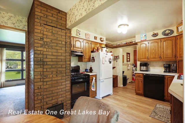 959 N Cass Ave, Vassar, MI 48768 - kitchen featuring black appliances, range hood, light countertops, wallpapered walls, and light wood-type flooring