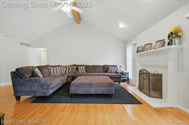 50064 Josephine Dr, Macomb, MI 48044 - living room featuring wood finished floors, beam ceiling, a ceiling fan, a fireplace, and high vaulted ceiling