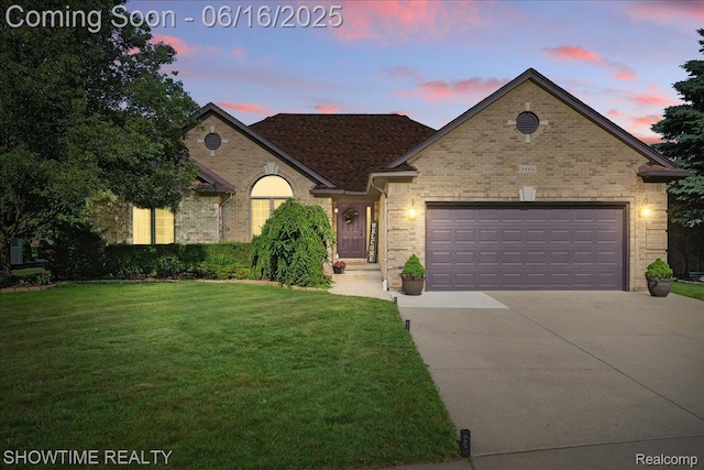 50064 Josephine Dr, Macomb, MI 48044 - view of front of home with concrete driveway, brick siding, a yard, and a garage