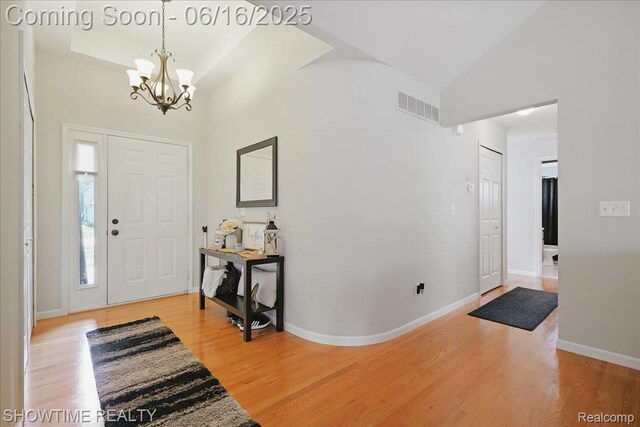 50064 Josephine Dr, Macomb, MI 48044 - foyer with a chandelier, high vaulted ceiling, and light wood-style flooring