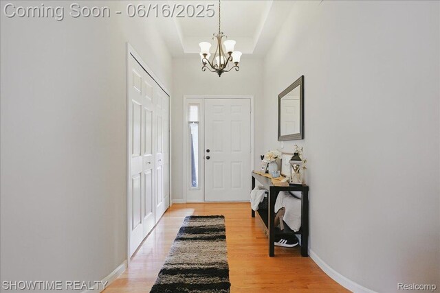 50064 Josephine Dr, Macomb, MI 48044 - foyer entrance with a chandelier, light wood finished floors, and a raised ceiling