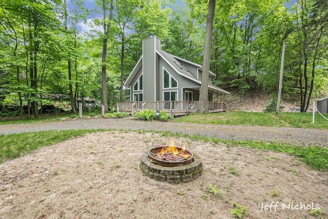 534 N Lighthouse Dr, Mears, MI 49436 - back of property with an outdoor fire pit, a wooden deck, and a chimney
