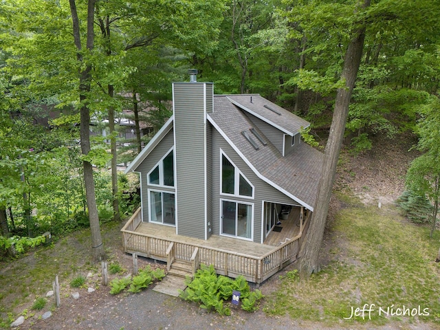 534 N Lighthouse Dr, Mears, MI 49436 - view of side of property featuring a chimney, roof with shingles, and a wooden deck