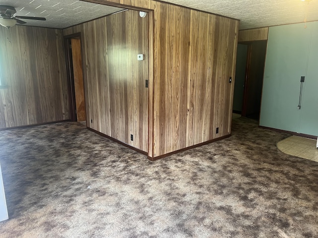 919 Nature Ln, Montgomery, MI 49255 - spare room with wooden walls, a ceiling fan, and carpet floors