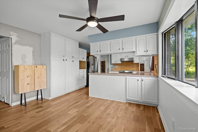 3757 Chase Lake Rd, Howell, MI 48855 - kitchen featuring white cabinetry, a peninsula, stainless steel fridge with ice dispenser, and light wood-style floors