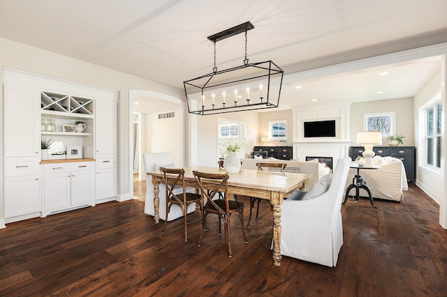 2377 Lake Birch Ct NE, Grand Rapids, MI 49525 - dining space featuring arched walkways, dark wood-style floors, a fireplace, and recessed lighting