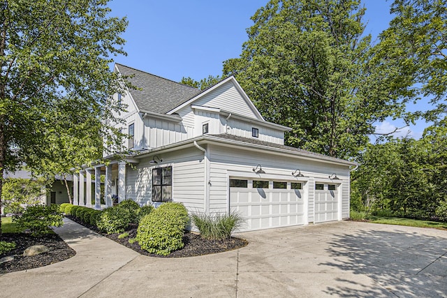 2377 Lake Birch Ct NE, Grand Rapids, MI 49525 - view of property exterior featuring board and batten siding, driveway, a garage, and roof with shingles