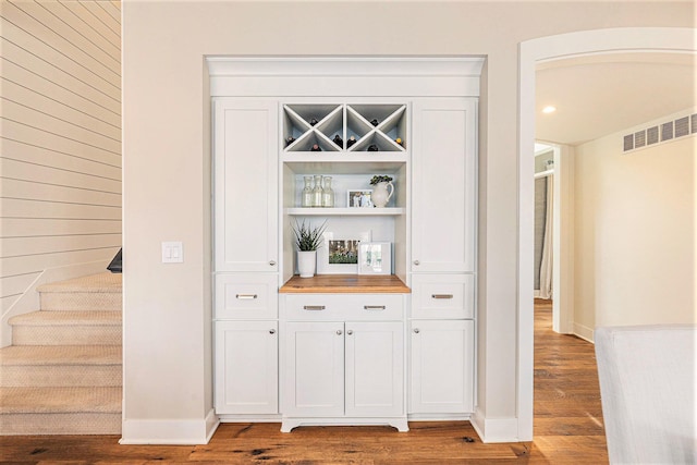 2377 Lake Birch Ct NE, Grand Rapids, MI 49525 - bar area with wood finished floors, wood walls, and stairway