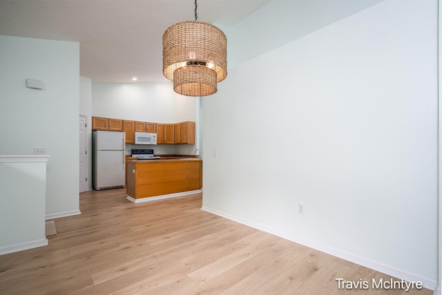 17909 Hidden Dunes Ln Unit B, Spring Lake, MI 49456 - kitchen featuring white appliances, a chandelier, light wood-type flooring, open floor plan, and recessed lighting