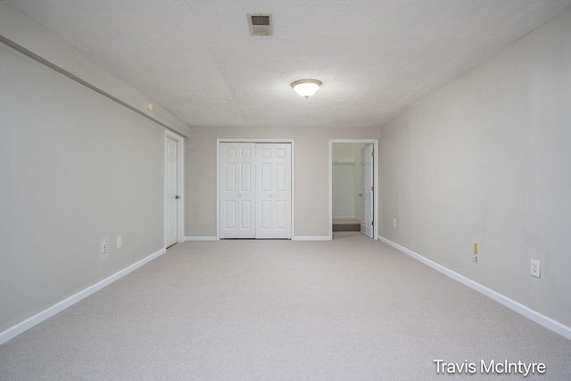 17909 Hidden Dunes Ln Unit B, Spring Lake, MI 49456 - unfurnished bedroom with light colored carpet, a closet, and a textured ceiling