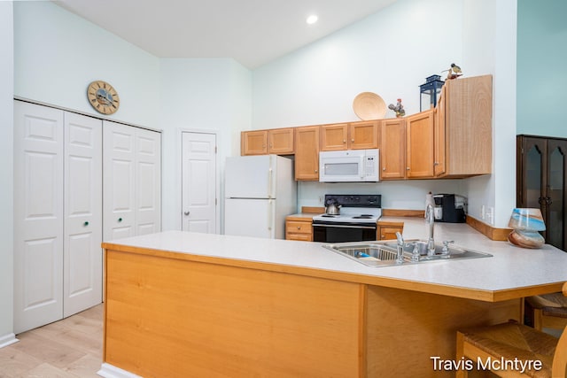 17909 Hidden Dunes Ln Unit B, Spring Lake, MI 49456 - kitchen featuring white appliances, a peninsula, light countertops, a towering ceiling, and a kitchen bar
