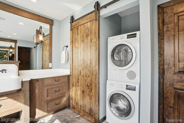 3806 Island Park Dr, Waterford, MI 48329 - laundry area with stacked washing machine and dryer, a barn door, recessed lighting, and light stone finish flooring