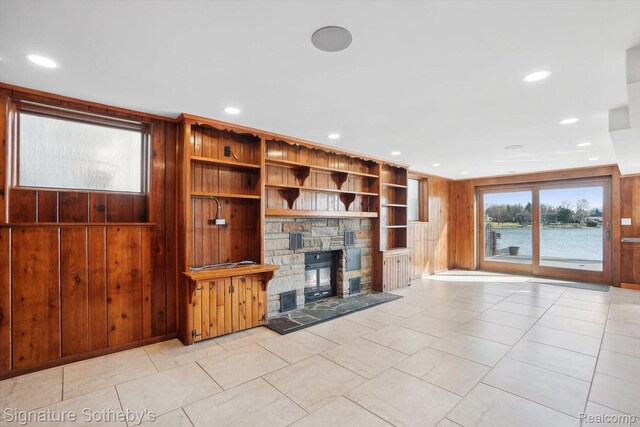 3806 Island Park Dr, Waterford, MI 48329 - unfurnished living room with a stone fireplace, wooden walls, recessed lighting, and light tile patterned floors
