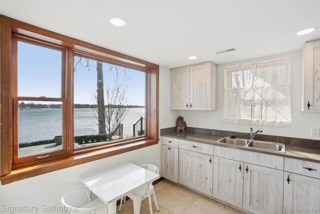 3806 Island Park Dr, Waterford, MI 48329 - kitchen featuring a water view, healthy amount of natural light, light tile patterned floors, dark countertops, and recessed lighting