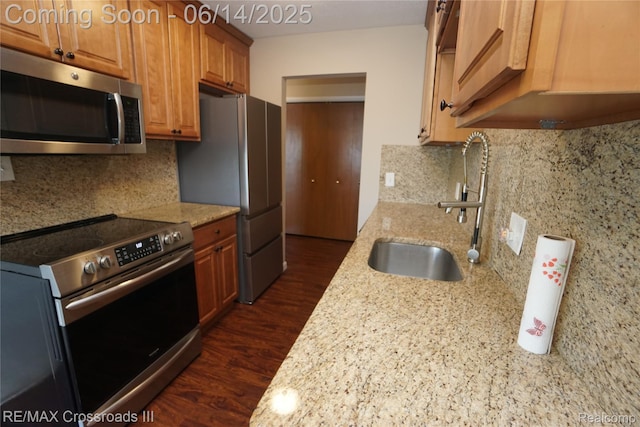 250 N Liberty St Unit 310, Belleville, MI 48111 - kitchen featuring stainless steel appliances, light stone countertops, decorative backsplash, dark wood-style floors, and brown cabinets