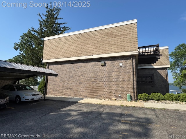 250 N Liberty St Unit 310, Belleville, MI 48111 - view of side of home with mansard roof, brick siding, a balcony, and roof with shingles