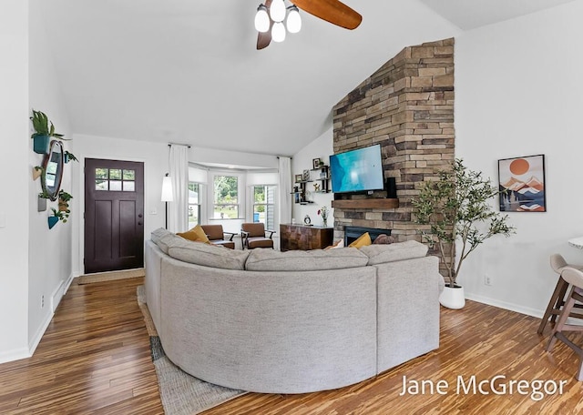 15159 Westray St, Grand Haven, MI 49417 - living area with wood finished floors, a stone fireplace, ceiling fan, and high vaulted ceiling