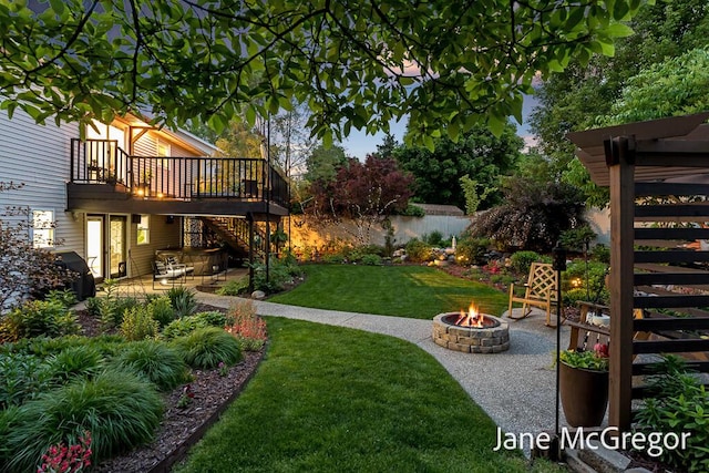 15159 Westray St, Grand Haven, MI 49417 - view of grassy yard with an outdoor fire pit, stairway, a deck with water view, and a patio