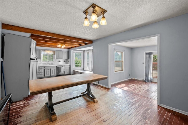 2144 Stanford Dr SE, Kentwood, MI 49508 - dining room with wood-type flooring, plenty of natural light, a chandelier, and beamed ceiling