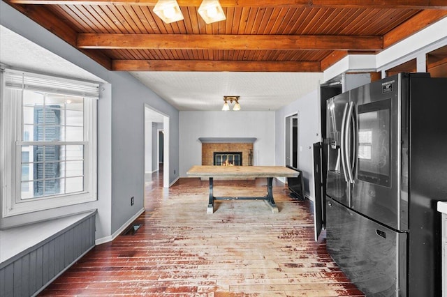 2144 Stanford Dr SE, Kentwood, MI 49508 - kitchen with stainless steel fridge, hardwood / wood-style floors, a wood ceiling with exposed beams, and a glass covered fireplace