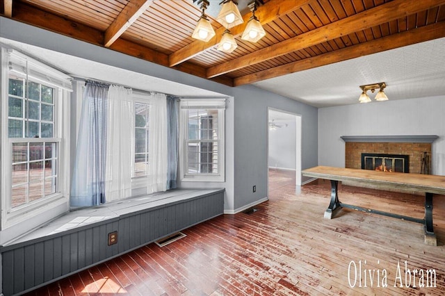 2144 Stanford Dr SE, Kentwood, MI 49508 - unfurnished living room featuring wood-type flooring, a brick fireplace, and a wooden ceiling with exposed beams