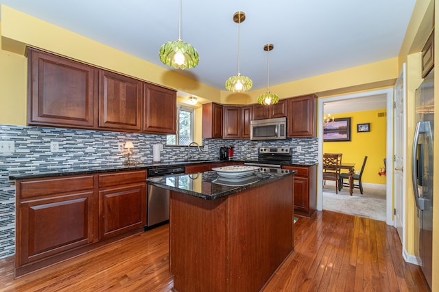 5992 Cedar Ridge Dr, Ann Arbor, MI 48103 - kitchen featuring stainless steel appliances, dark wood-style flooring, a center island, tasteful backsplash, and pendant lighting
