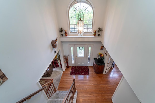 5992 Cedar Ridge Dr, Ann Arbor, MI 48103 - foyer featuring a high ceiling, wood finished floors, a chandelier, and stairs