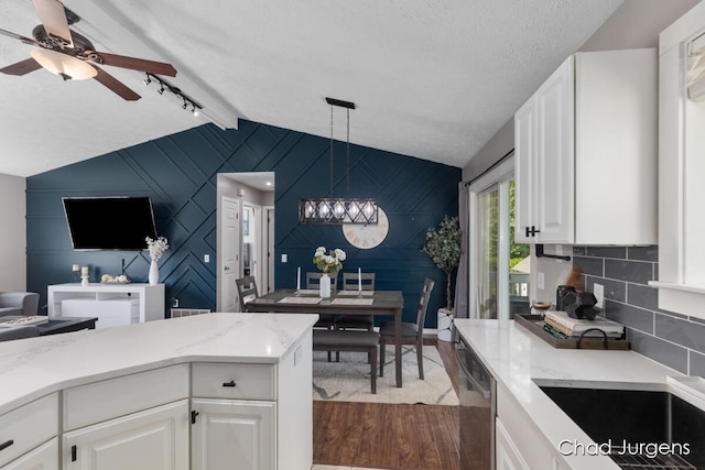 647 Maynard NW, Grand Rapids, MI 49504 - kitchen featuring lofted ceiling, an accent wall, a chandelier, dark wood-style flooring, and stainless steel dishwasher