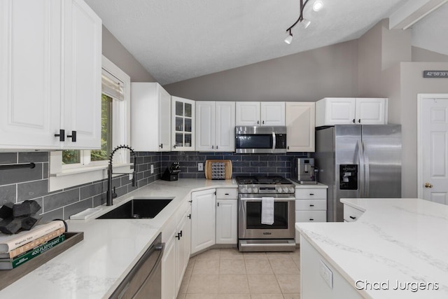 647 Maynard NW, Grand Rapids, MI 49504 - kitchen featuring appliances with stainless steel finishes, lofted ceiling, backsplash, light stone countertops, and white cabinetry
