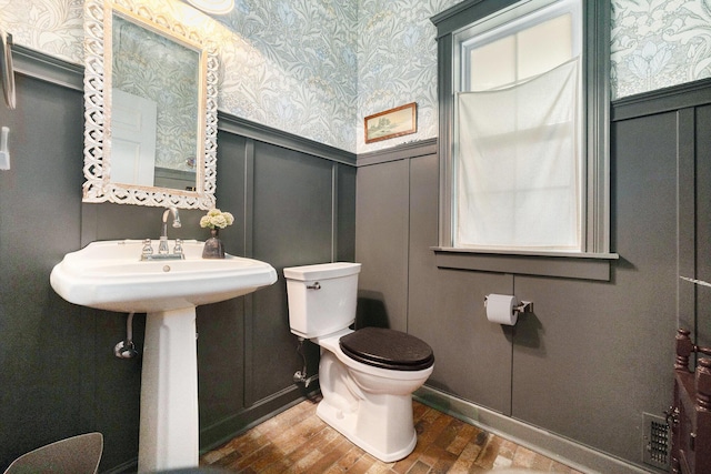 2975 Pine Edge Ct, Holland, MI 49424 - bathroom with wallpapered walls, a decorative wall, wainscoting, and wood finished floors